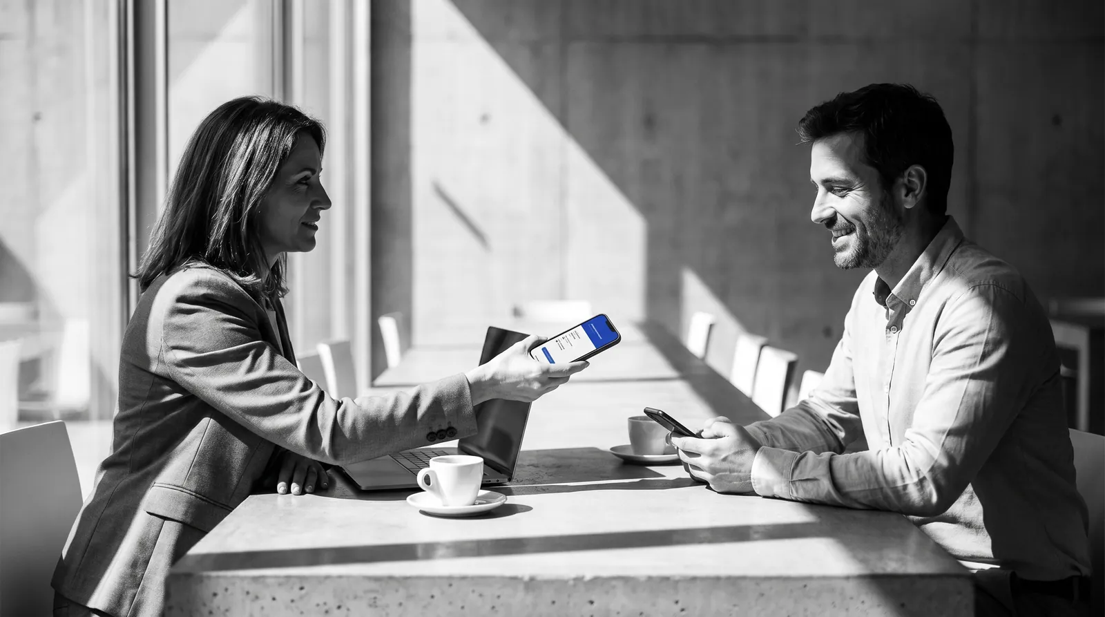 Una directiva enseña su tarjeta digital en el móvil a un cliente que guarda el contacto